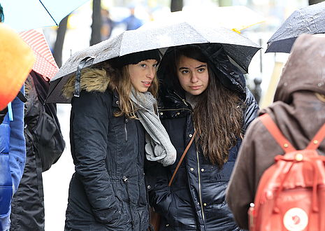 Two participants under an umbrella.